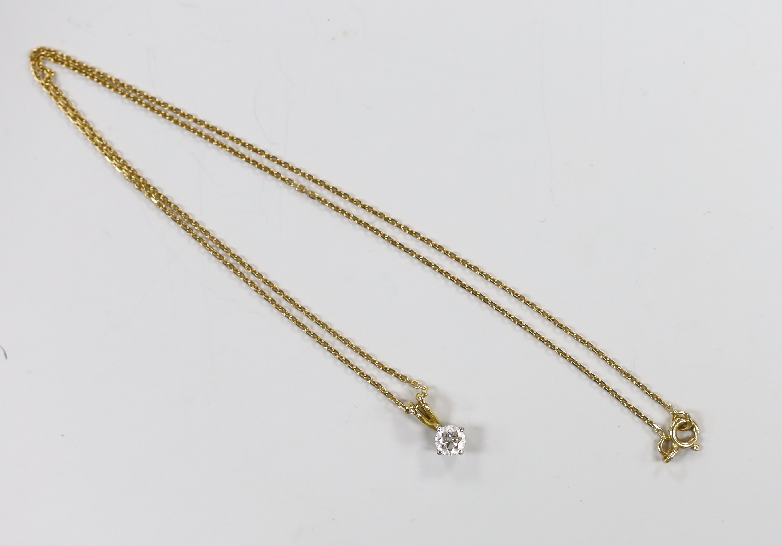 A modern 18ct gold and solitaire diamond set pendant, 10mm, on an 18ct gold chain, 40cm, gross weight 2.8 grams.